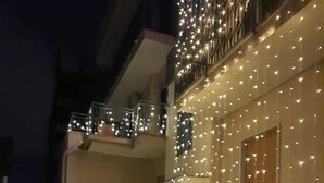 A building with multiple balconies, each adorned with string lights. - POMPEI - LARA SUITE (Scafati)