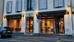 Un edificio con un letrero que dice "ZADIG" y un letrero de no estacionamiento.