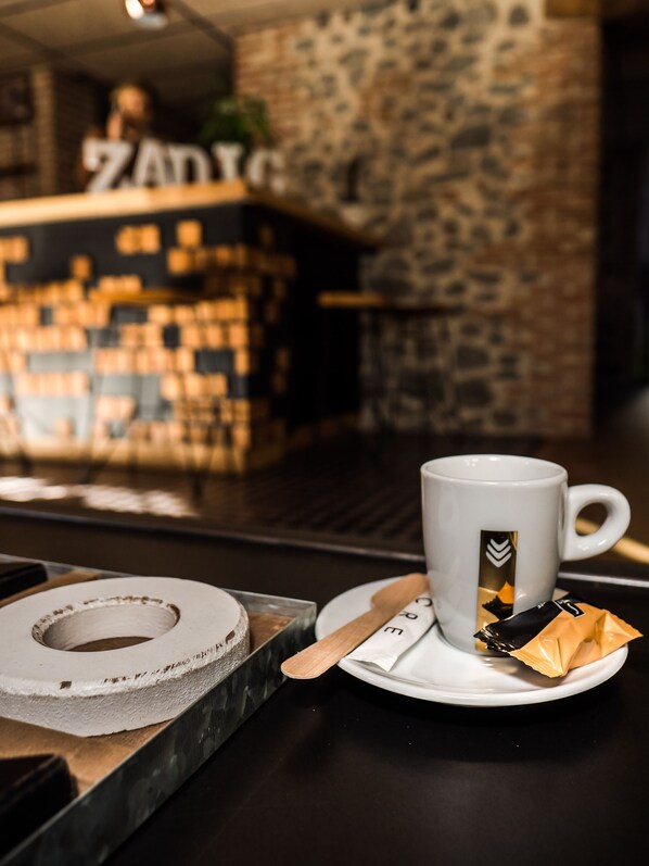 Una taza de café con un logotipo, una servilleta y un posavasos sobre una mesa.