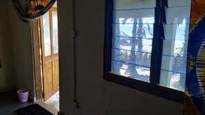A room with a window, a door, and a small mat on the floor. - Unspoiled South Gambian Paradise '' Paradise Roundhouse '' (Kartung)