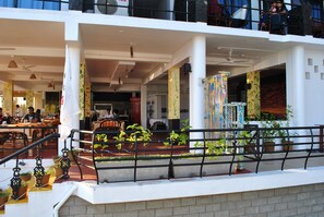 Un espace public intérieur doté de coins salon, de colonnes et de plantes en pot.