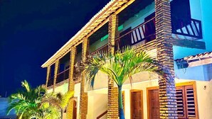 A two-story building with a brick facade, multiple windows, and a balcony. - Pousada Jardins do Mar (Cascavel)