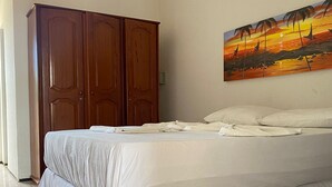 A bedroom with a bed, a wardrobe, and a painting on the wall. - Pousada Jardins do Mar (Cascavel)