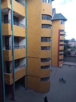 A multi-story building with balconies and a curved corner.