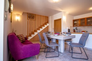 Une cuisine moderne avec des meubles en bois, une table à manger avec des chaises et un escalier avec des rampes en bois.
