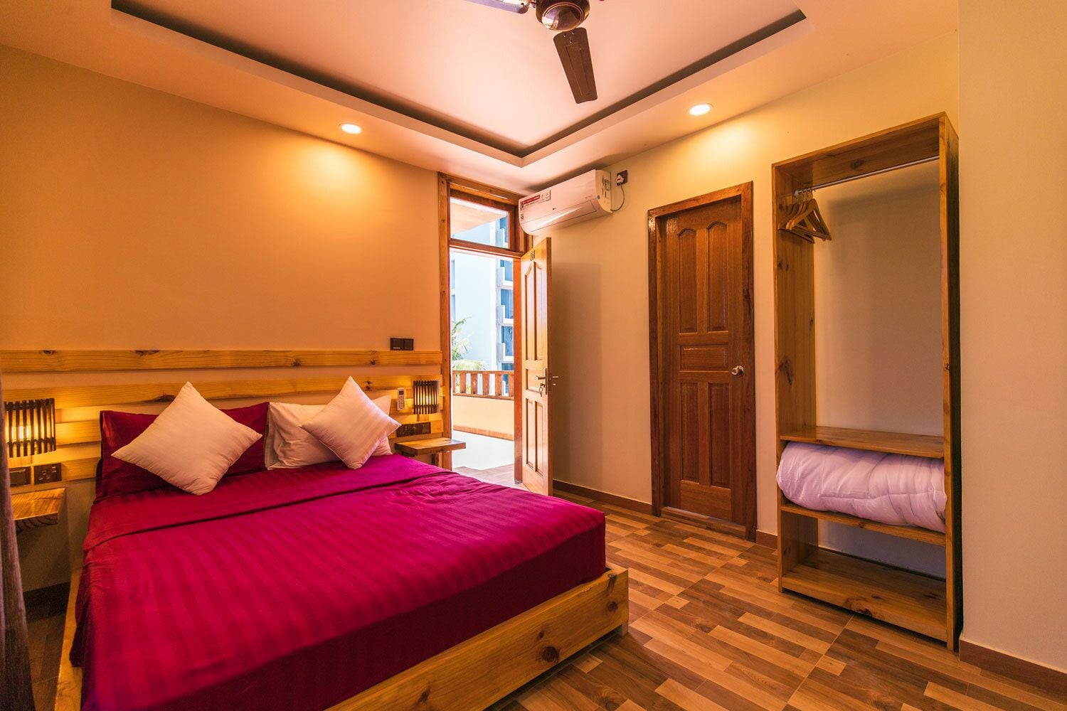 A bedroom with a wooden bed, a wooden wardrobe, and a balcony door.