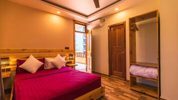 A bedroom with a wooden bed, a wooden wardrobe, and a balcony door.