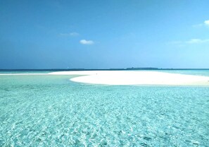 Una playa con agua turquesa cristalina y una zona de arena blanca.