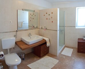 Een badkamer met toilet, wastafel en douche.