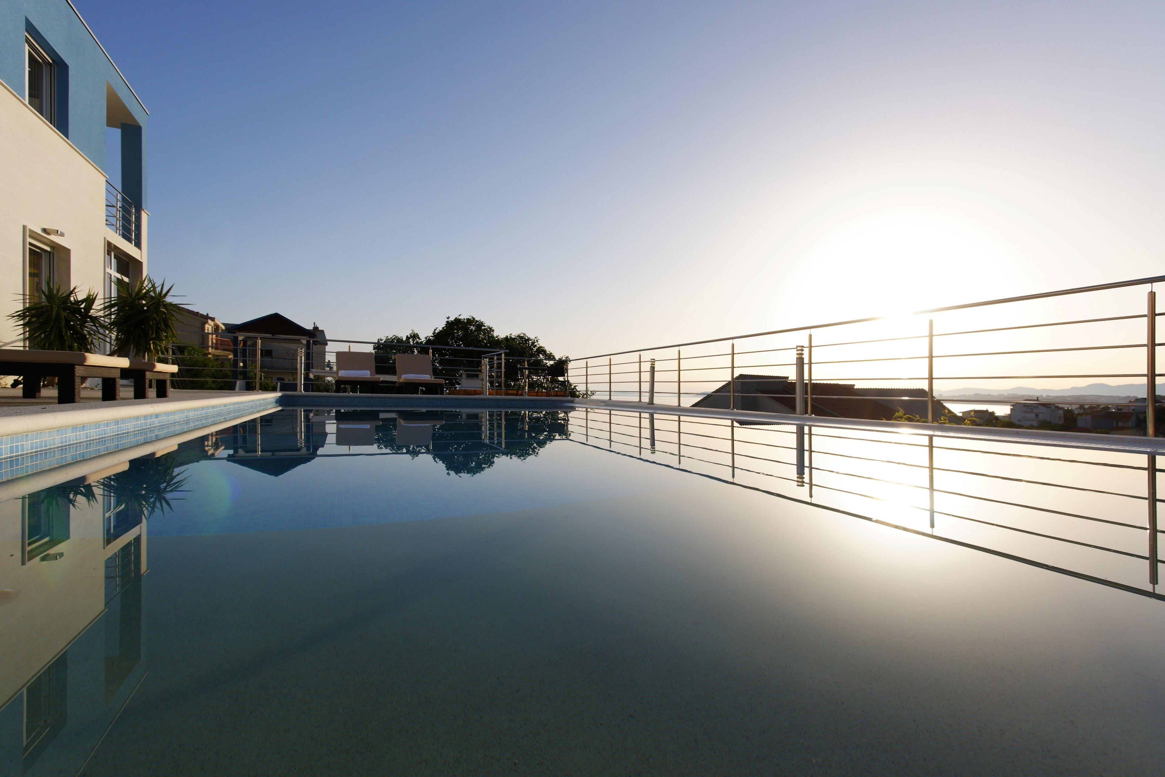 A swimming pool with a clear view of a building and a distant landscape.
