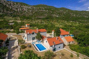 Zona residencial amb cases, una piscina i un paisatge de muntanyes al fons.