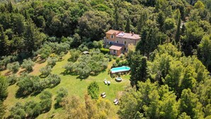 An aerial view of a house surrounded by dense forest, with a swimming pool and outdoor seating area. - La Locanda del Barbagianni (Santa Luce)