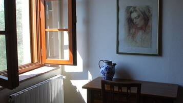 Doppia Romantica, 1 letto queen, vista giardino | Area soggiorno | TV a schermo piatto, libri