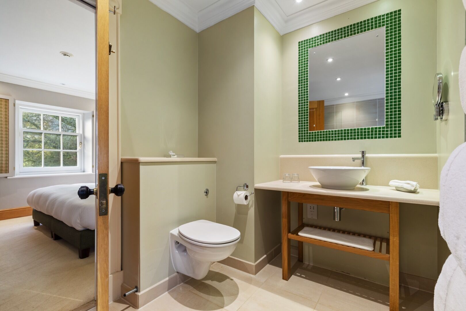 A modern bathroom with a toilet, sink, and mirror.
