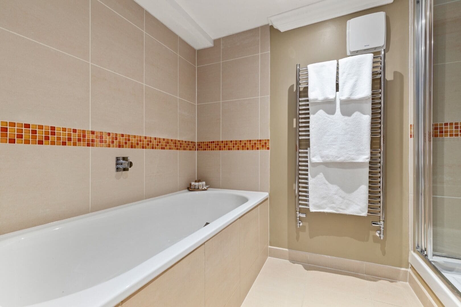 Une salle de bain avec une baignoire, une douche et un porte-serviettes.