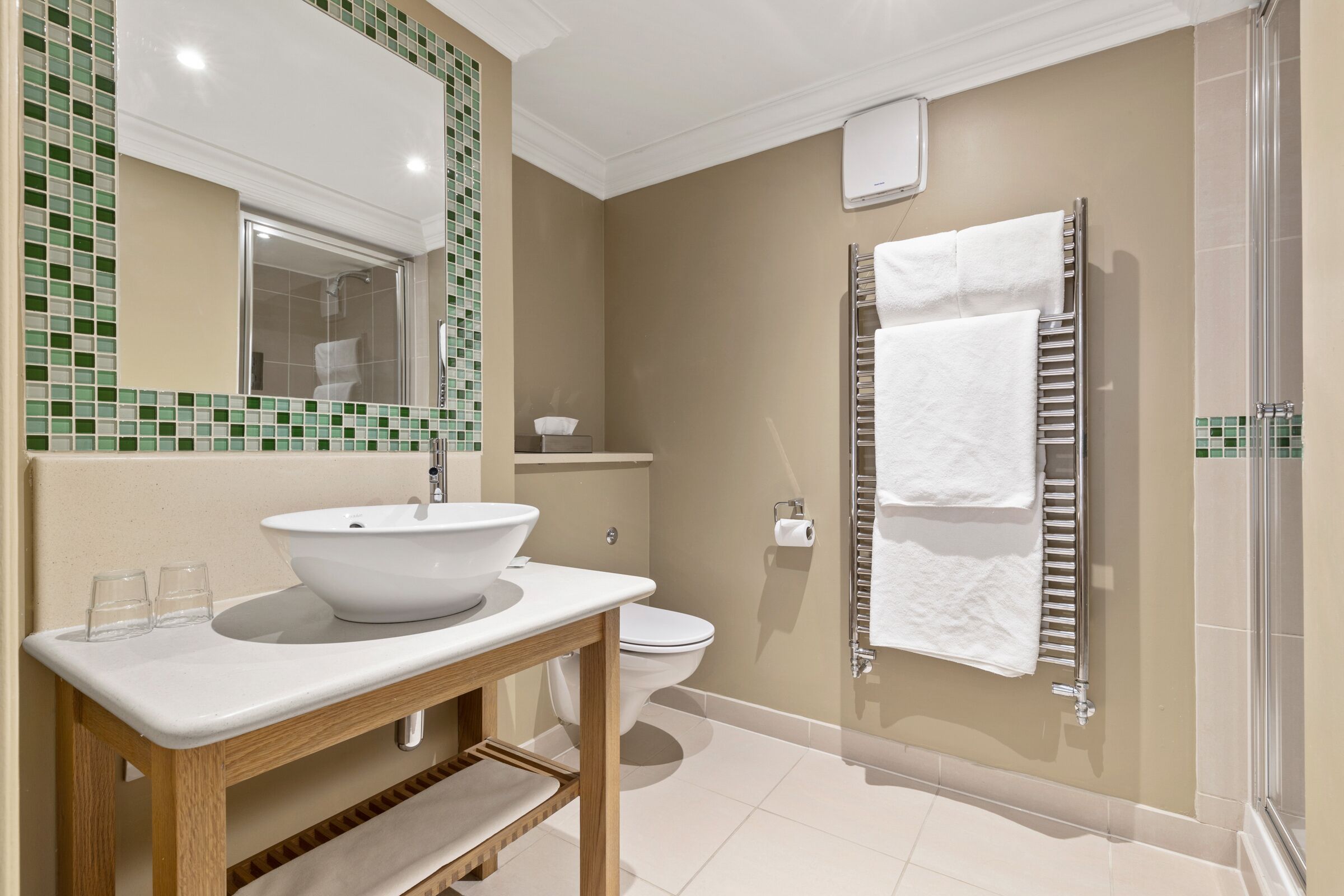 Een moderne badkamer met een groot wastafel, spiegel en douche.