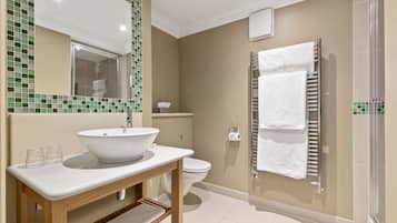 Een moderne badkamer met een groot wastafel, spiegel en douche.