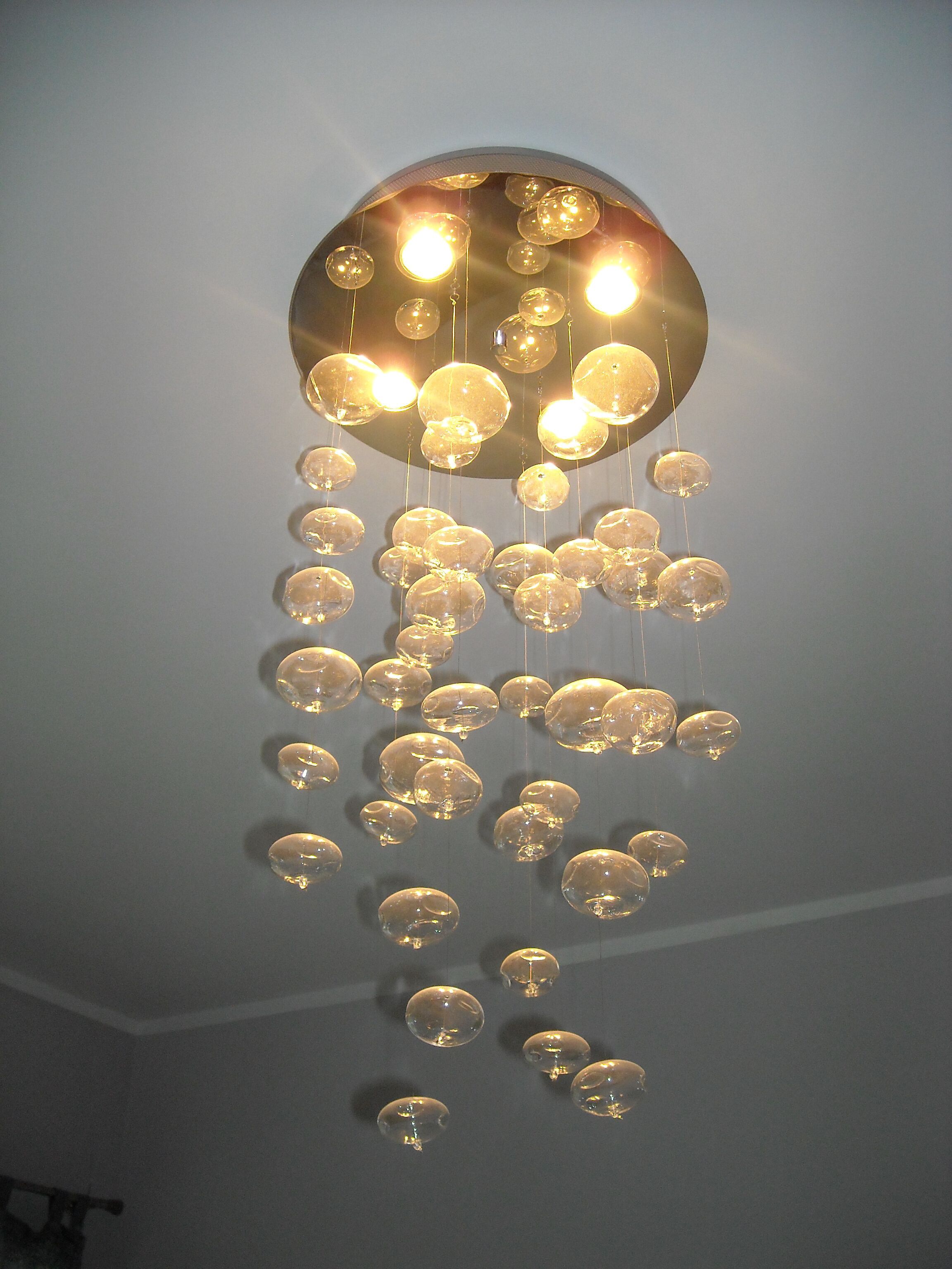 Et loft med en kugleformet lampe og flere hængende lamper.