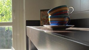 Una encimera de cocina con una taza colorida y una caja de bicarbonato de sodio.