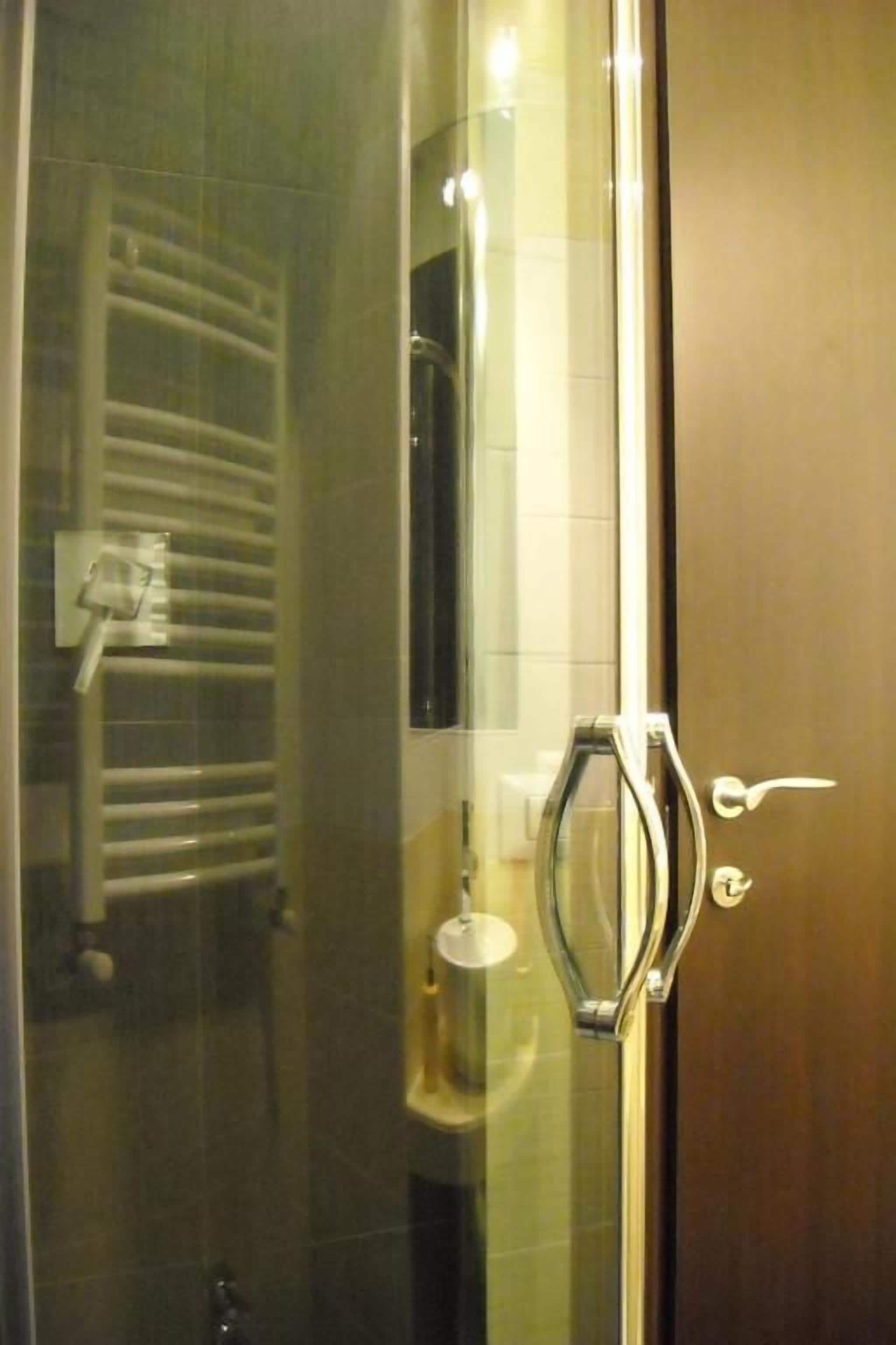 A glass door with a towel rack and a towel dispenser inside a room.