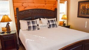 A bed with a headboard, two bedside lamps, and a pillow with 'welcome to our nest' text. - Brookstone Lodge - 6 Bedroom -Dog Friendly-Pool Access-Theater-Game Room-Hot Tub (Sevierville)