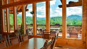 A wooden cabin with large windows overlooking a forested mountain range. - Brookstone Lodge - 6 Bedroom -Dog Friendly-Pool Access-Theater-Game Room-Hot Tub (Sevierville)