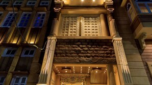 Ein mehrgeschossiges Gebäude mit einem prachtvollen Eingang, der sich durch aufwendige Säulen und eine reich verzierte Fassade auszeichnet.