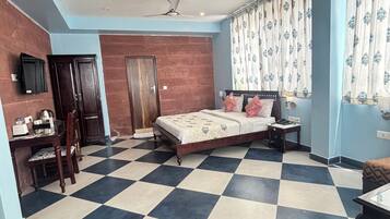 Quarto com piso xadrez, cama, escrivaninha e guarda-roupa.
