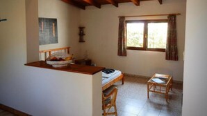 A small, cozy room with a wooden ceiling, a bed, a desk, and a window with curtains. - Palmera, quiet studio with terrace and view to the mountains (Las Zocas)