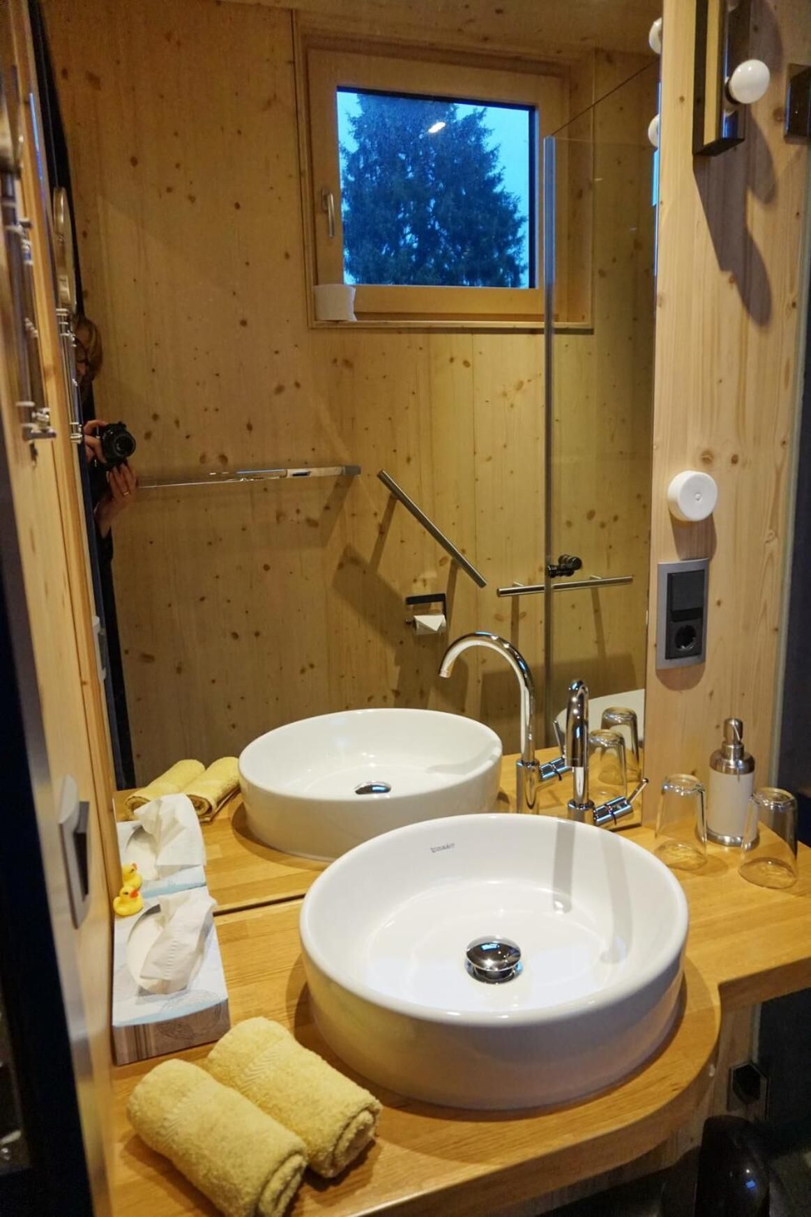 A bathroom with two sinks, a mirror, and a window.