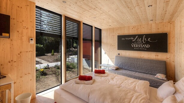 Un dormitorio moderno con una cama grande, un sofá y vistas al exterior.