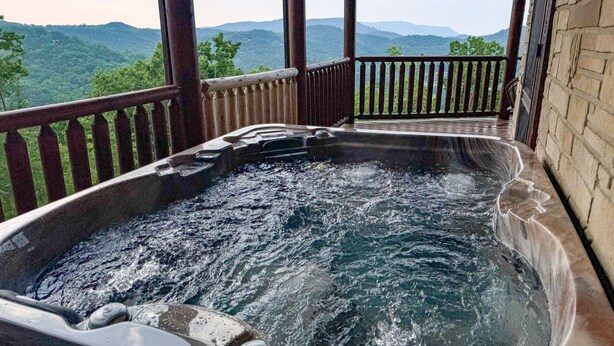 A hot tub with a wooden deck and a view of the mountains. - Paradise Found - Cabin (Sevierville)