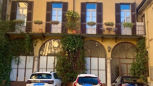 Un edificio con tres coches aparcados en la calle.
