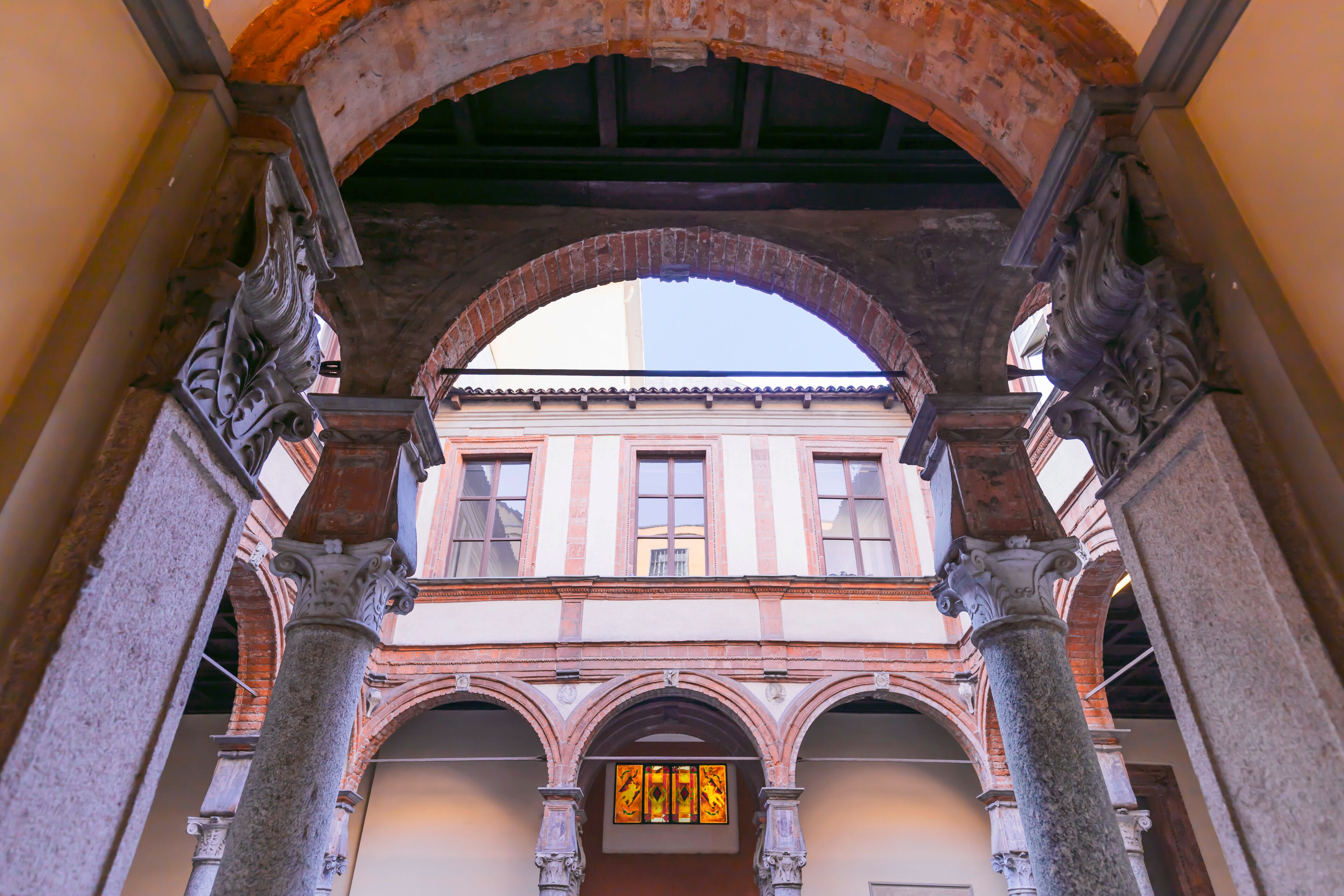 Eine Bogenarchitektur mit Säulen und einem Gebäude im Hintergrund.