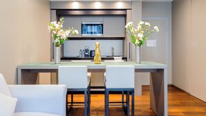 Una cucina moderna con isola centrale, due sedie e un vaso con fiori.