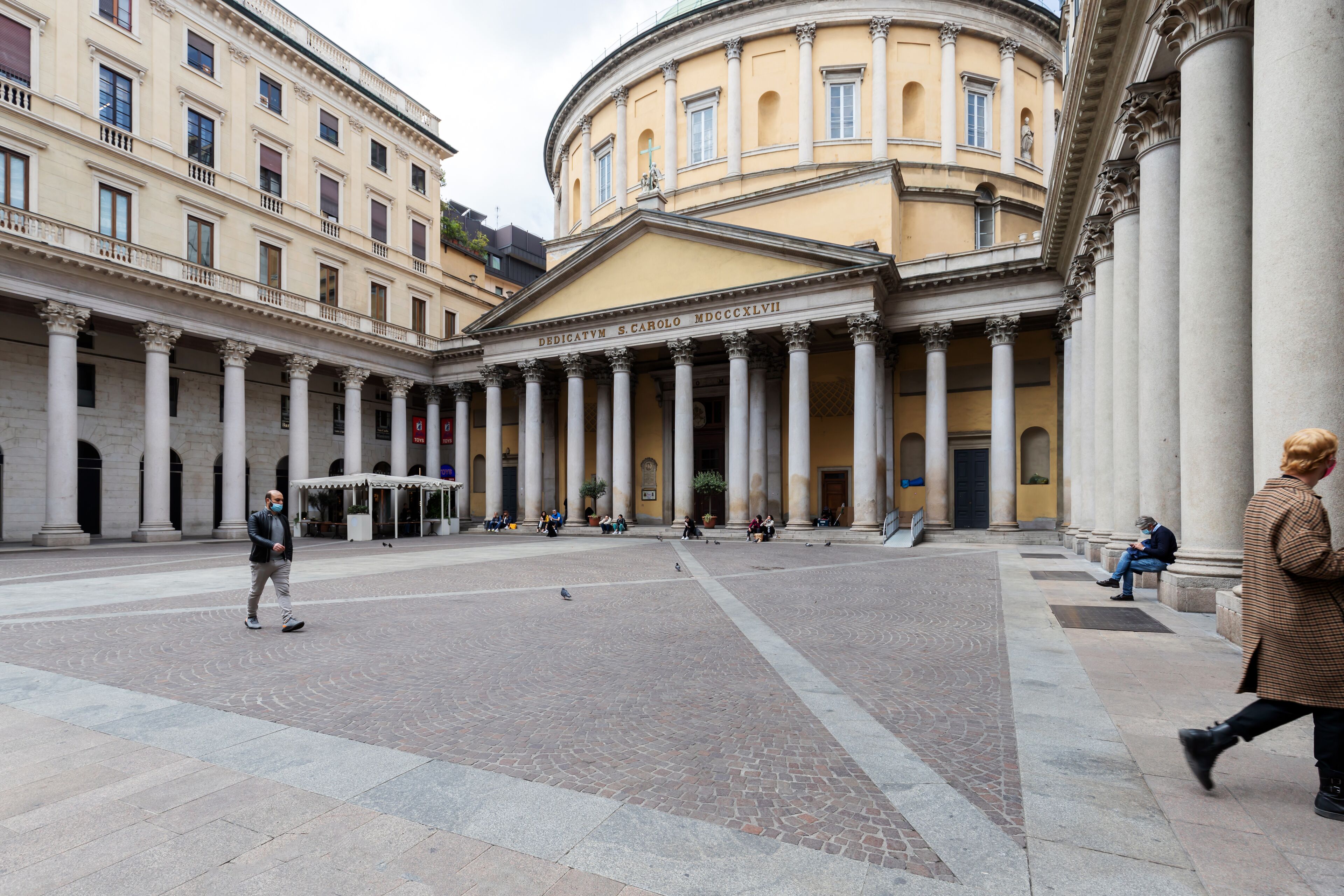 Un patio con arquitectura clásica, con columnas y un edificio central con inscripciones.