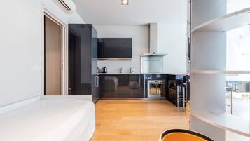 Una habitación de hotel moderna con una cama, kitchenette y baño.