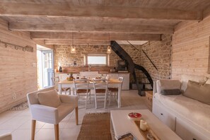 Un intérieur chaleureux comprenant un coin repas, une cuisine et un espace salon.