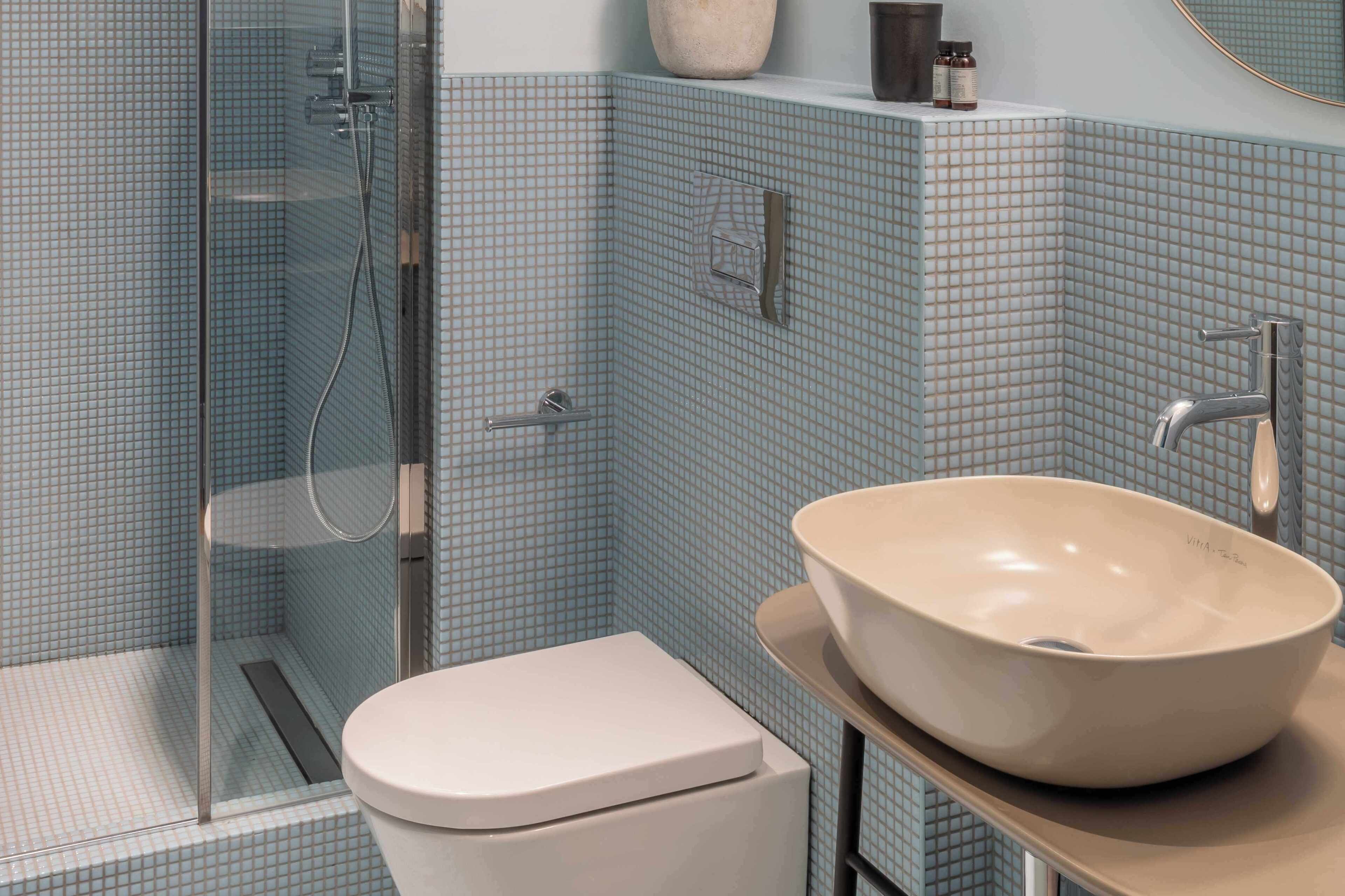 Un bagno con box doccia in vetro, un water e un lavabo a vasca.