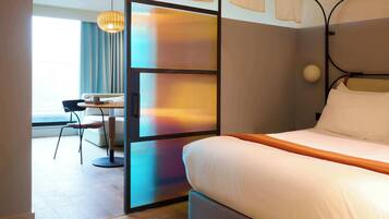 A hotel room with a bed, a desk, and a chair.