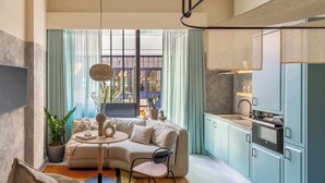 A modern living room with a sofa, a dining table, and a kitchen area with cabinets and appliances. - Bermonds Locke, Tower Bridge (London)