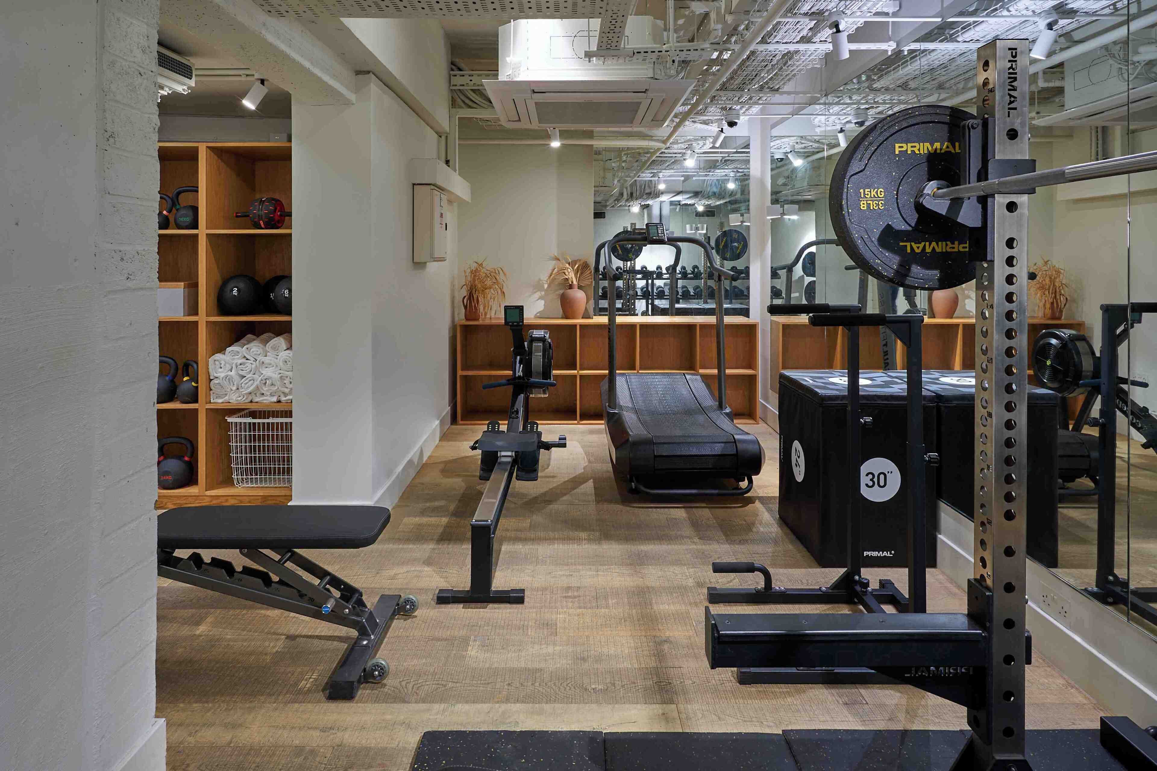 A gym with weightlifting equipment, treadmills, and a bench.