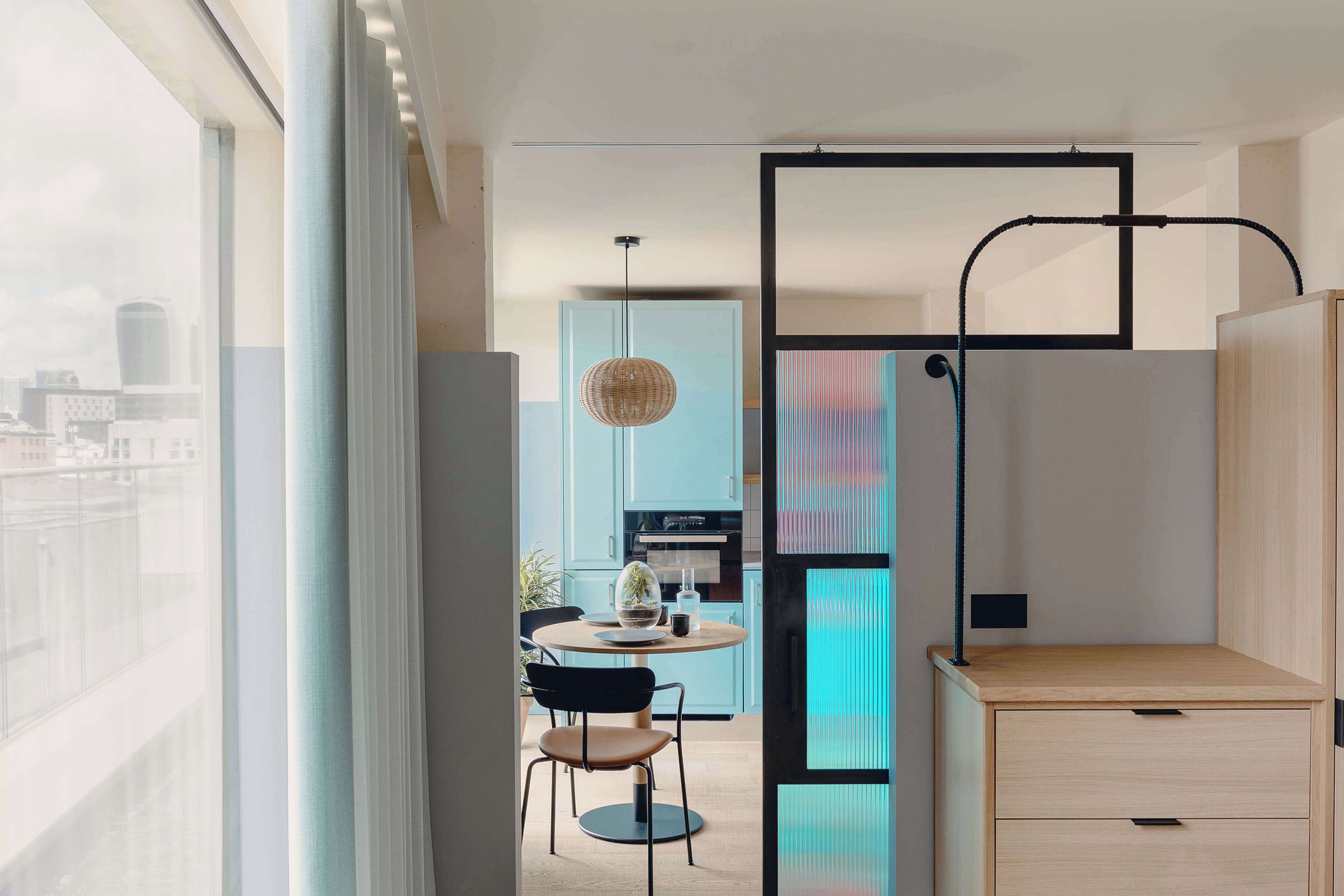 Un interior moderno con comedor, cocina y vistas de la ciudad.