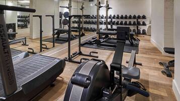 A gym with exercise equipment, weight racks, and treadmills.