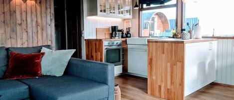 A modern kitchen with wooden cabinets, a built-in oven, and a central island.