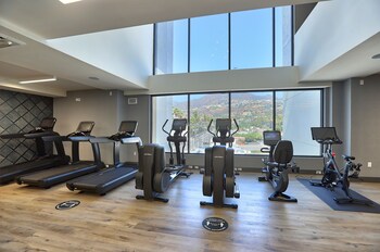 A modern hotel with a glass facade, multiple floors, and a prominent address sign. at The Glenmark, Glendale, a Tribute Portfolio Hotel