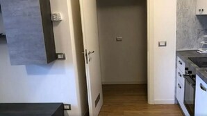 Eine moderne Küche mit weißen Schränken, Holzboden und einer grauen Spritzschutzwand.
