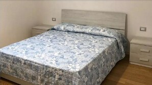 Ein Schlafzimmer mit einem Bett, einem Nachttisch und einer Kommode.