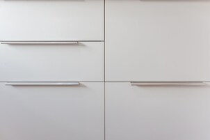 A clean, minimalist room with four white cabinets and two drawers.