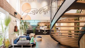 A modern interior with a reception desk, seating area, and a spiral staircase. - Maverick Central Market (Budapest)